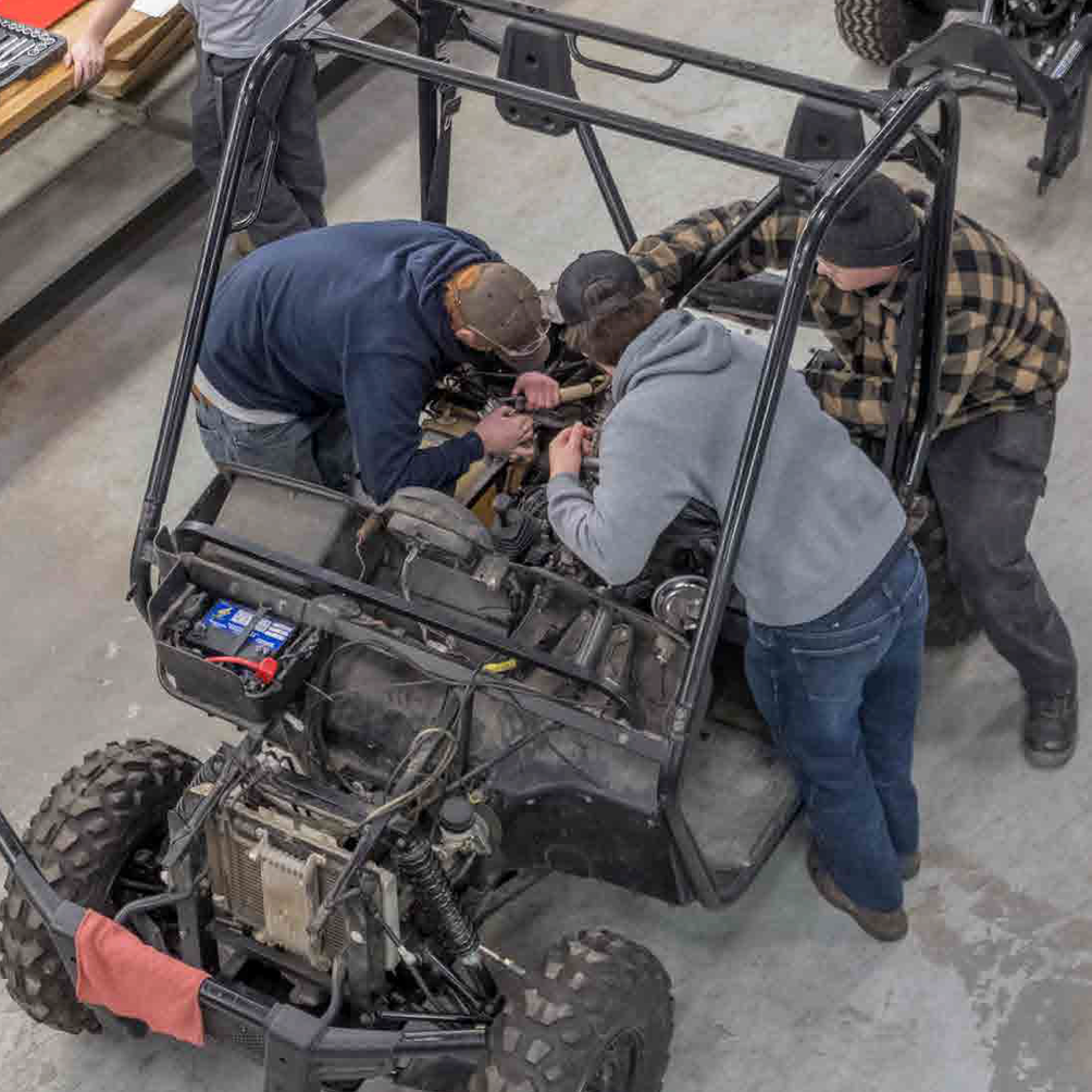Manufacturing workers building the engine of a vehicle.